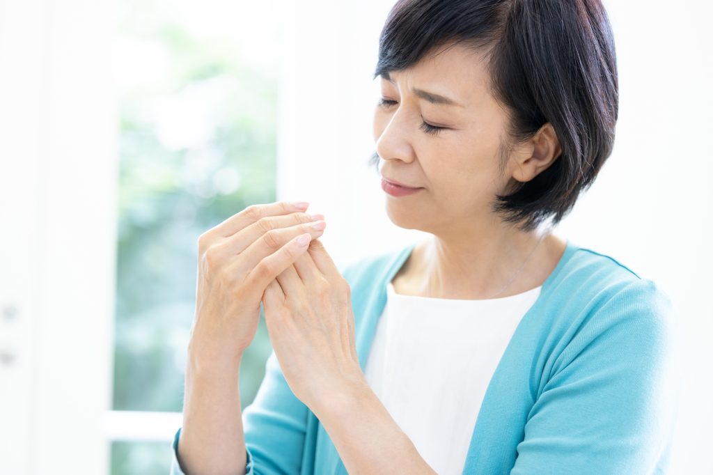 指が痛くて悩む女性
