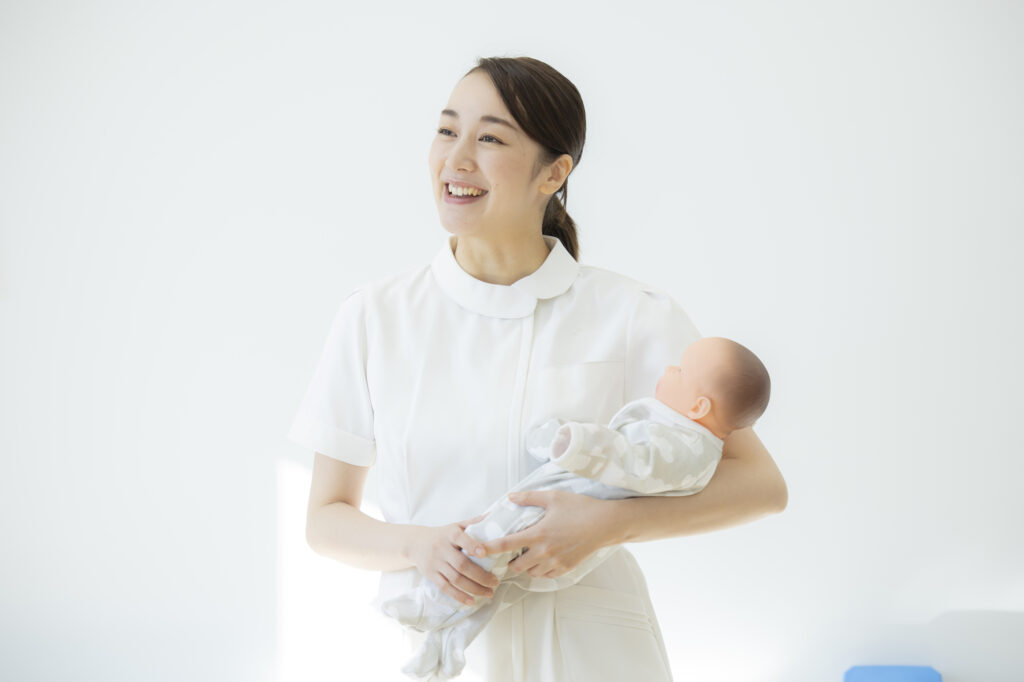 赤ちゃんを抱く助産師。妊娠・産後の健康と未来の更年期を考えるイメージ