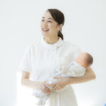 赤ちゃんを抱く助産師。妊娠・産後の健康と未来の更年期を考えるイメージ
