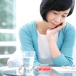 更年期症状の原因を整理して理解しようとしている女性のイメージ。エストロゲン低下と自律神経の不調の違いを考えている様子